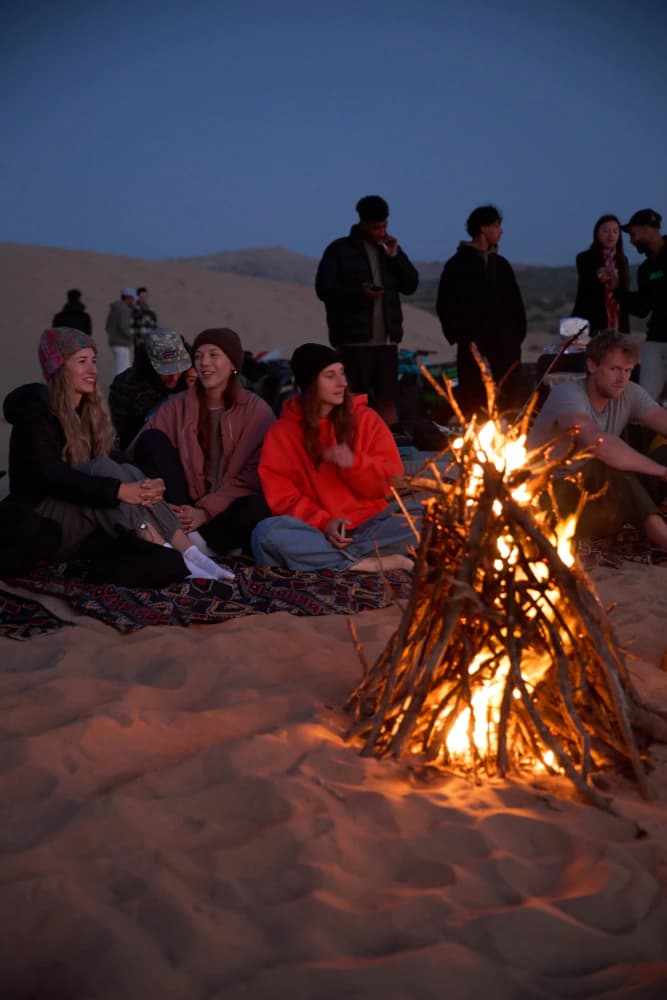 Campfire circle in sand dunes at Aman Surf & Yoga in Imsouane, Morocco