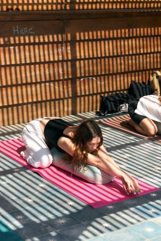 Child pose under rooftop pergola at Aman Surf & Yoga in Imsouane, Morocco