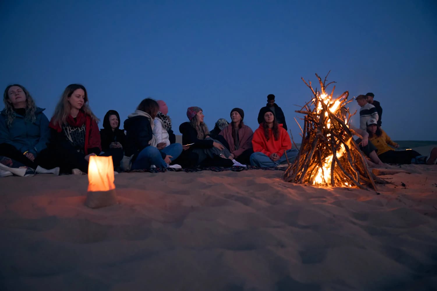 Desert bonfire gathering at dusk at Aman Surf & Yoga in Imsouane, Morocco