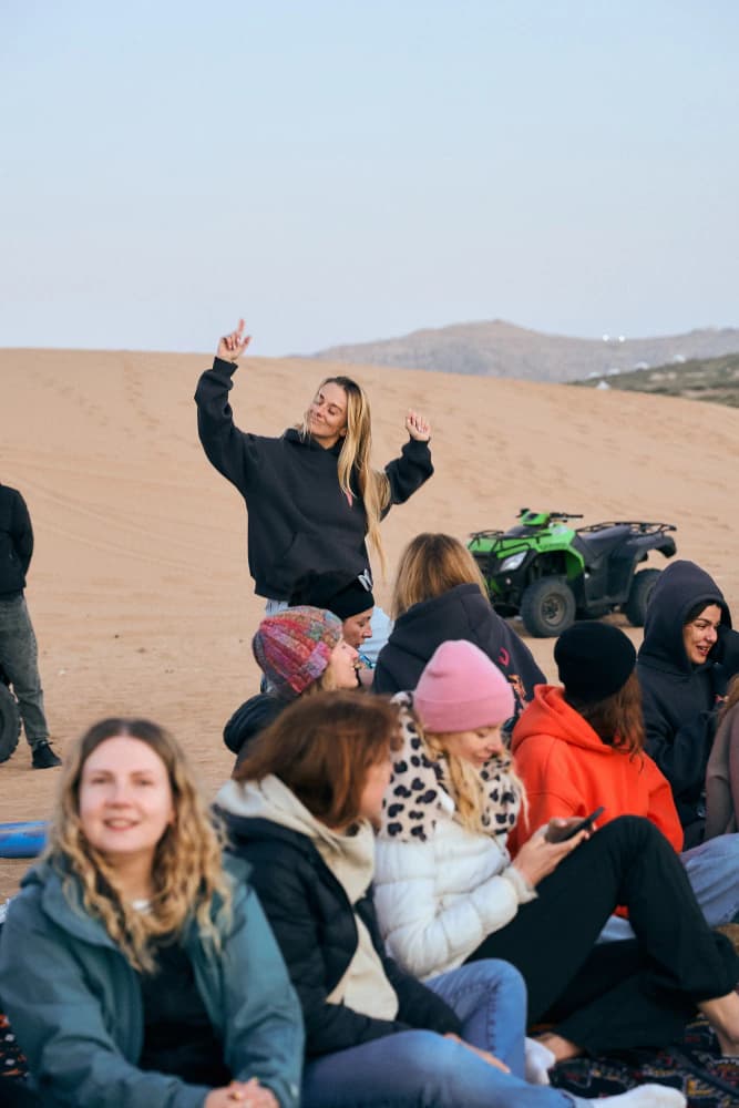 Desert camp guests waving at Aman Surf & Yoga in Imsouane, Morocco