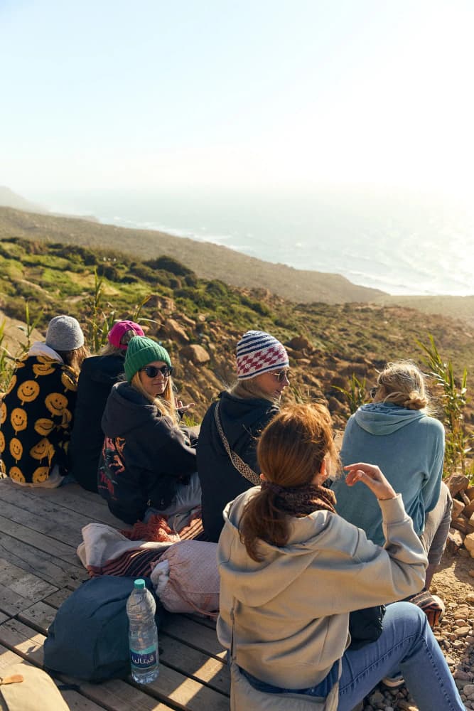 Friends overlooking atlantic coast at Aman Surf & Yoga in Imsouane, Morocco