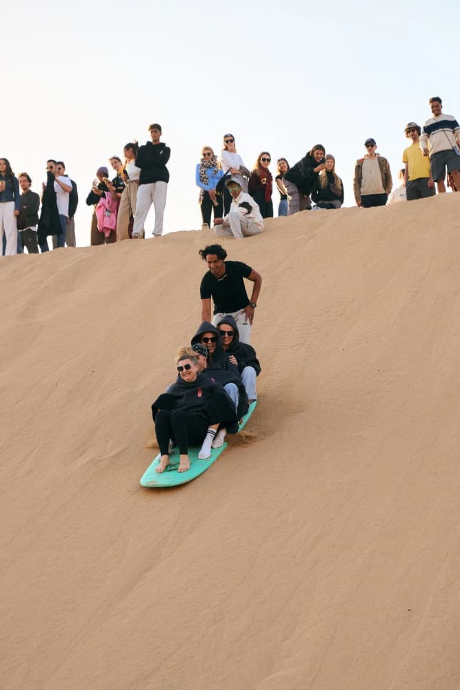 Friends tandem sandboarding at Aman Surf & Yoga in Imsouane, Morocco