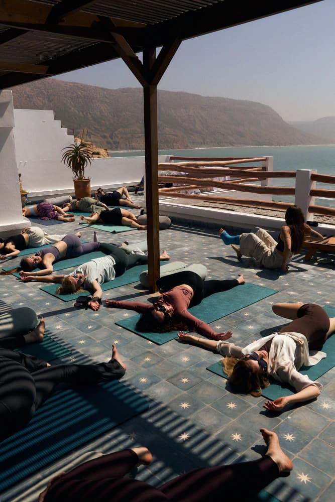 Group savasana under pergola at Aman Surf & Yoga in Imsouane, Morocco