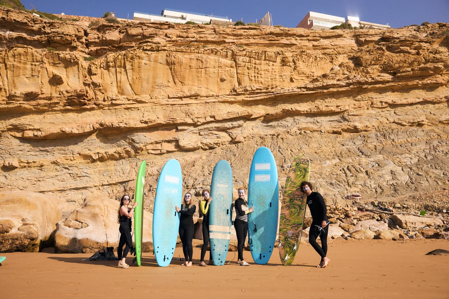 Retreat group with surfboards on beach at Aman Surf & Yoga in Imsouane, Morocco