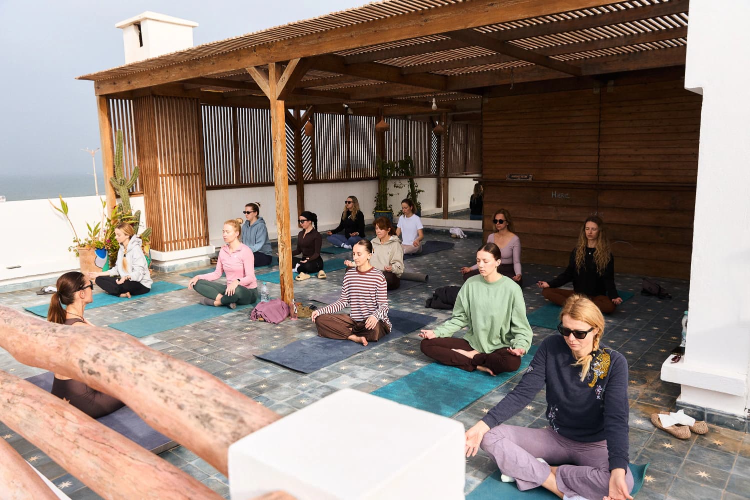 Seated rooftop yoga session at Aman Surf & Yoga in Imsouane, Morocco