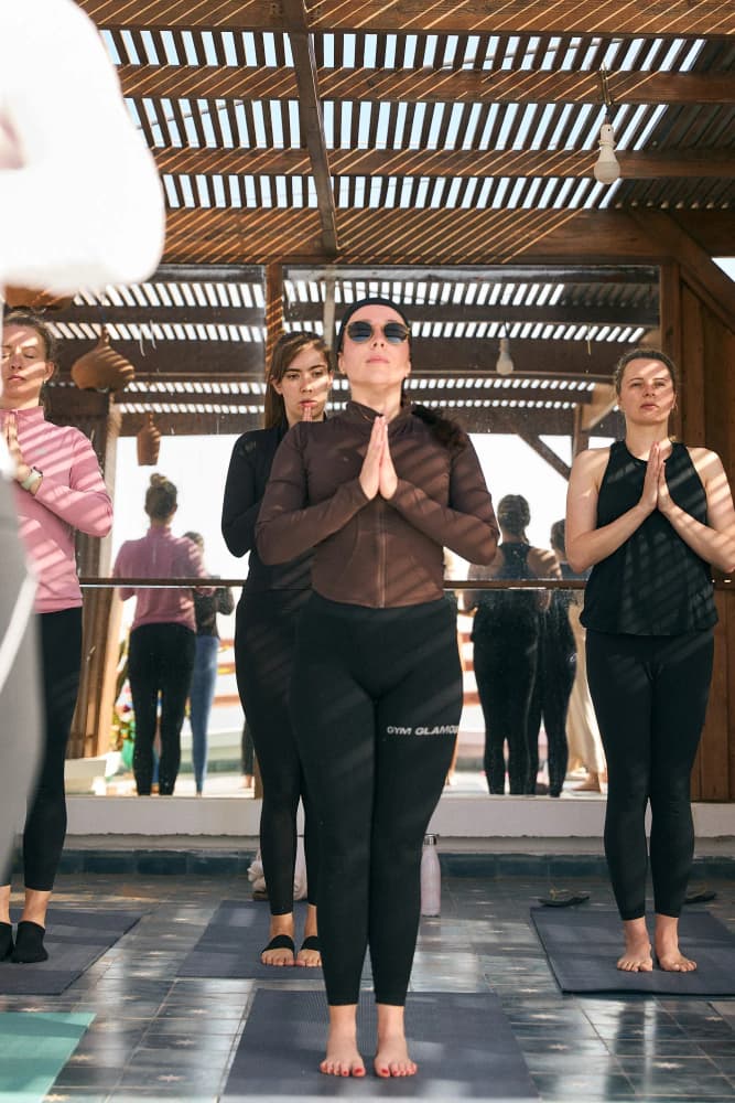 Standing prayer pose yoga group at Aman Surf & Yoga in Imsouane, Morocco