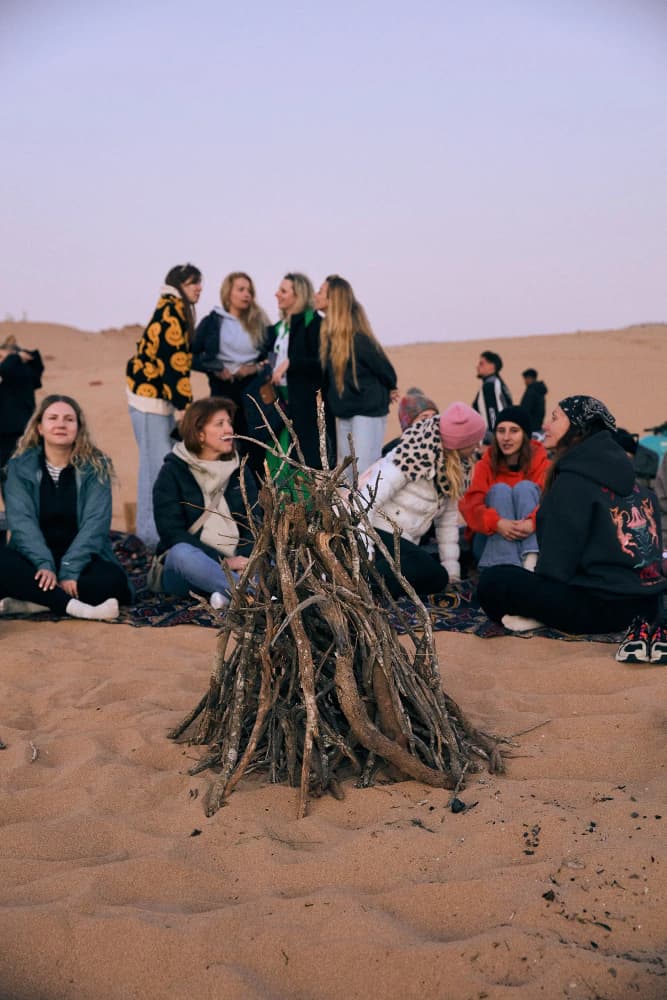 Sunset gathering around bonfire at Aman Surf & Yoga in Imsouane, Morocco