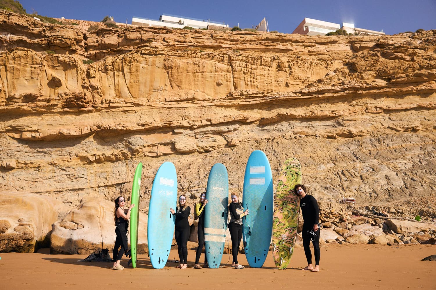 Surfboards lined up against cliff at Aman Surf & Yoga in Imsouane, Morocco