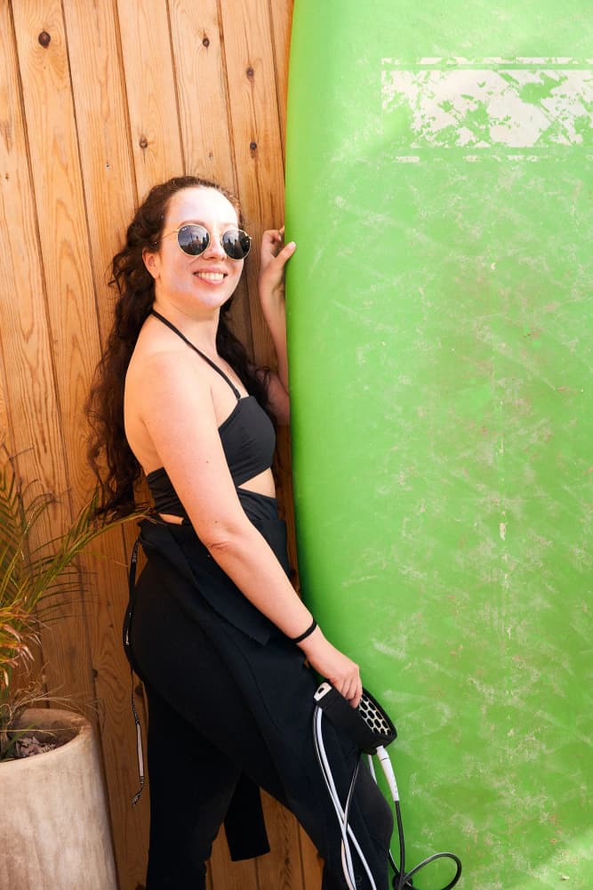 Woman with green surfboard portrait at Aman Surf & Yoga in Imsouane, Morocco