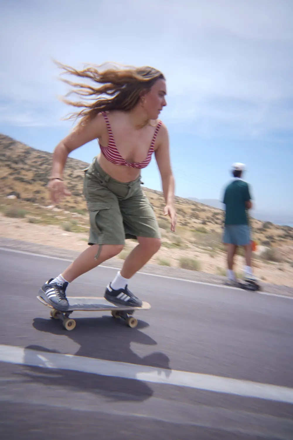 Woman carving on a surfskate along the coastal road above Imsouane, Morocco.